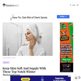 Header image of a woman with a towel on her head looking at her skin the bathroom mirror.