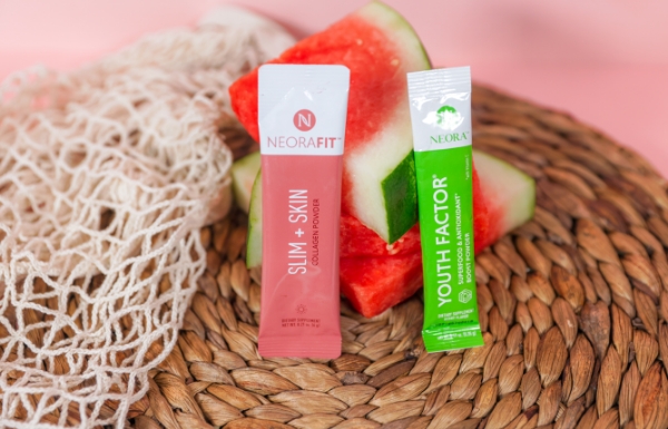 NeoraFit Slim + Glow Collagen Powder and Youth Factor Superfood & Antioxidant Boost Powder laying on a plate with watermelon